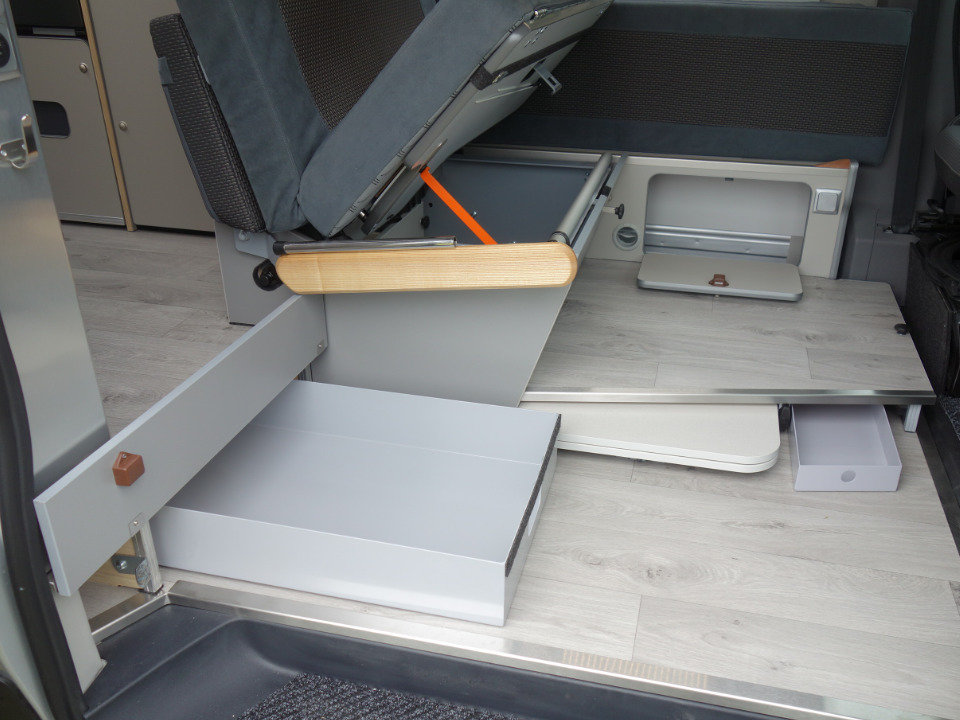 Blick auf den Eingangsbreich des Campmobils mit aufgeklappten Schubfächern