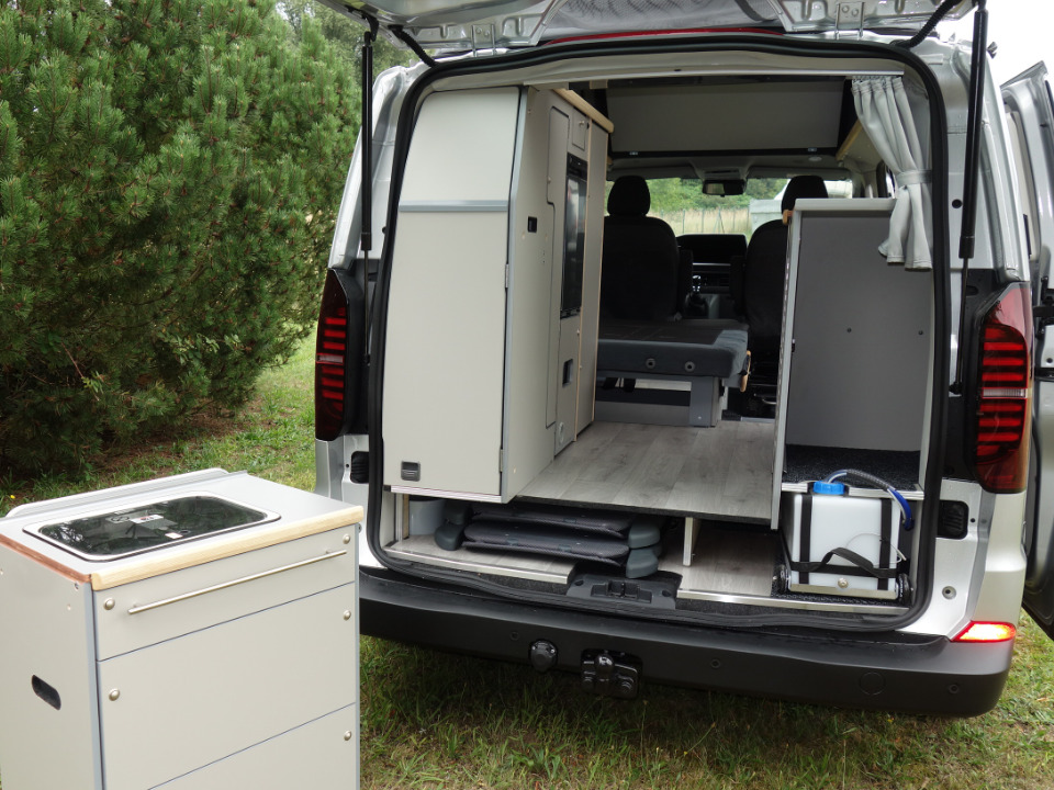 Blick auf die Heckküche des Campmobils mit abgestelltem Heckschrank